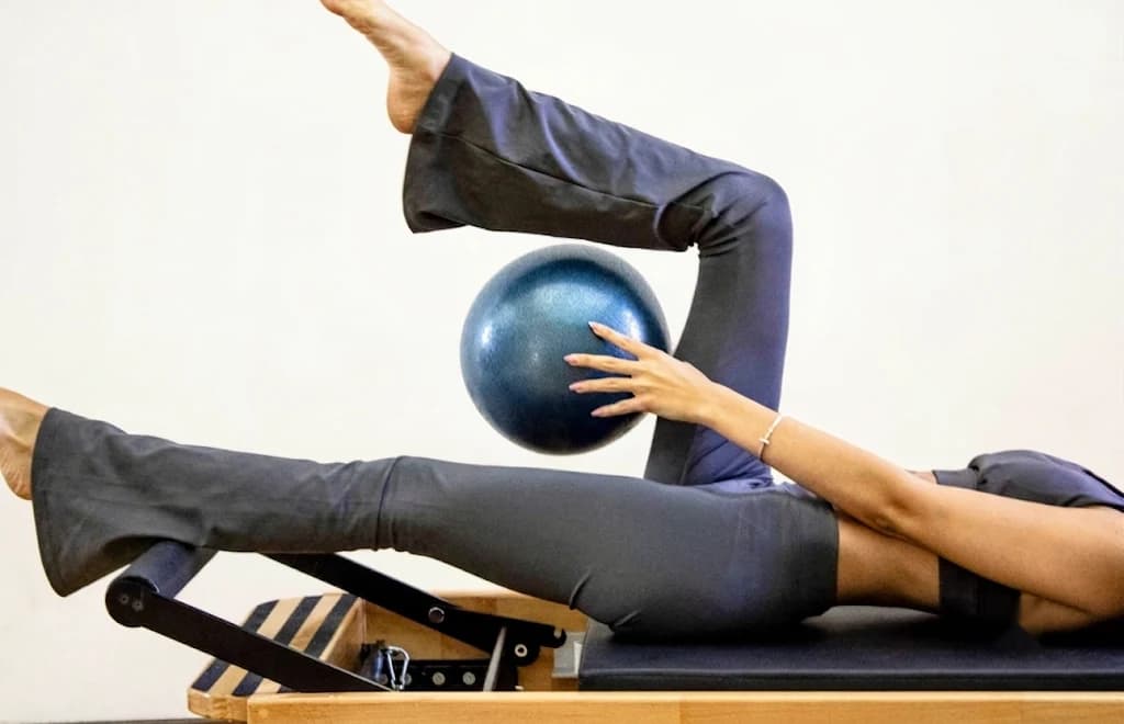 Vežba na reformeru sa pilates loptom u studiju